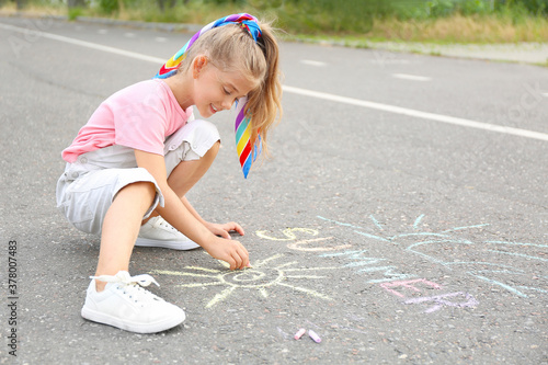 Little girl drawing with ch...