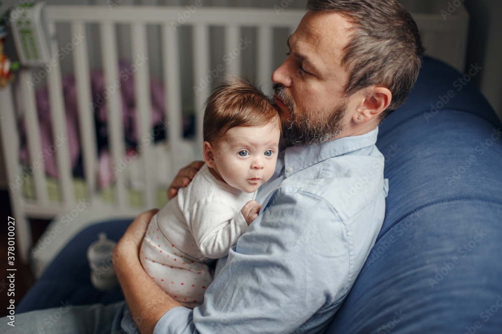 Middle age Caucasian father hugging newborn baby. Male man parent holding child on his arms. Authentic lifestyle documenatry moment. Single dad family life. Fathers Day holiday. Middle age Caucasian father hugging newborn baby. Male man parent holding child on his arms. Authentic lifestyle documenatry moment. Single dad family life. Fathers Day holiday.