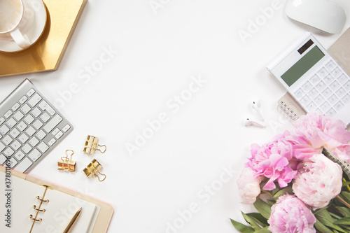 Top view of stylish office desk accessories with keyboard and cup of cappuccino on the gold tray.