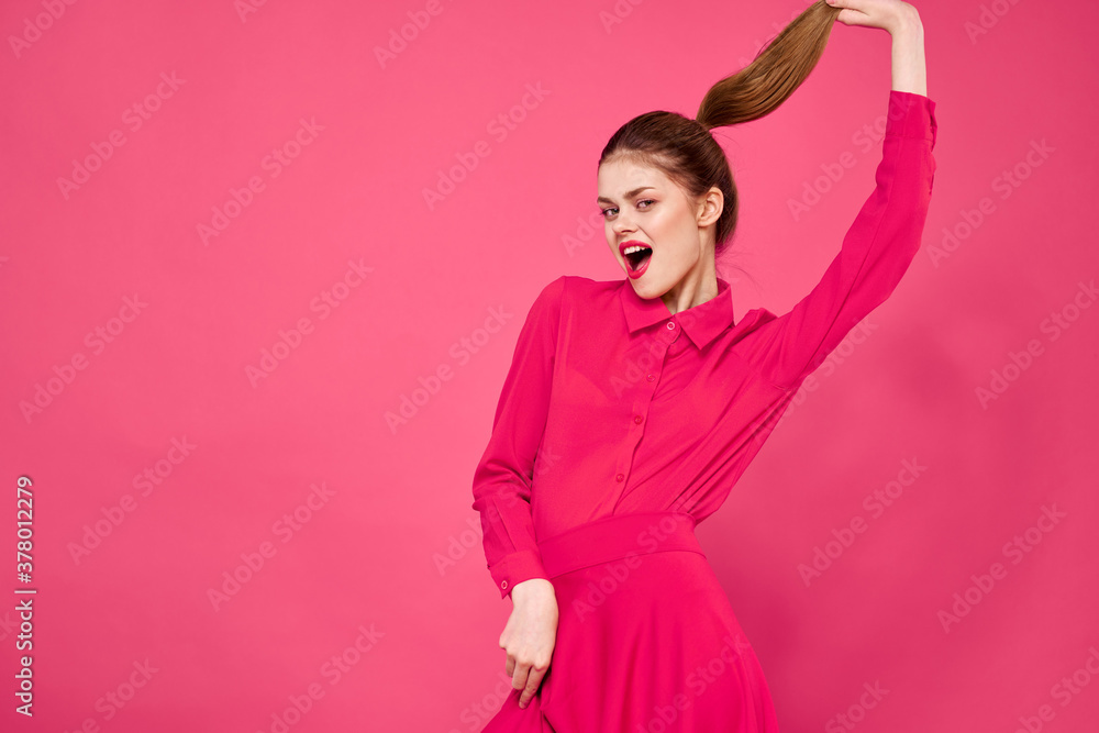 Portrait of a red-haired woman in bright clothes on a pink background cropped view of gesturing with her hands Portrait of a red-haired woman in bright clothes on a pink background cropped view of gesturing with her hands
