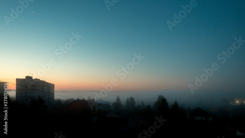 Venus in the sky before dawn over the city, a landscape with thick fog.