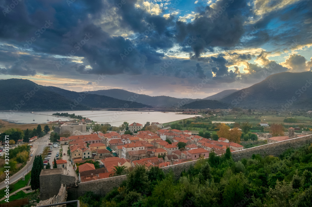 Dramatic sunset sky above Maly Ston castle and salt mines on the Adriatic Coast of Croatia