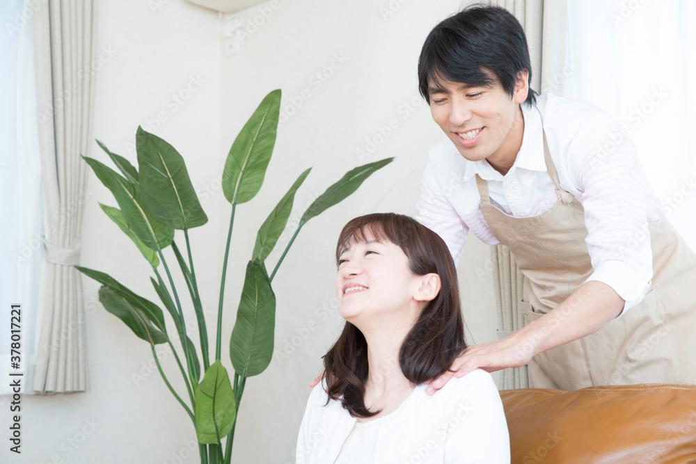 肩もみをする夫