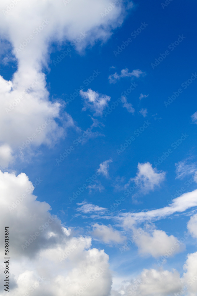 Vertical photo. Blue sky and white clouds in a circle. Frame made of white clouds on a sunny day. Natural background. Vertical photo. Blue sky and white clouds in a circle. Frame made of white clouds on a sunny day. Natural background.
