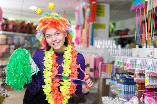 Positive girl looking for funny things in store of festival outfits and accessories