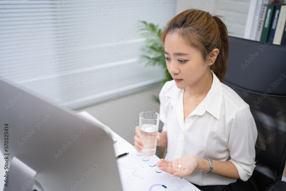 Asian Business woman drinking water and taking medicine. Asian Business woman drinking water and taking medicine.