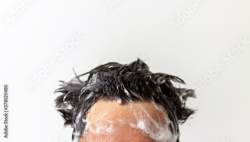 Male head with foam on hair close up on white background, copy space. © TATIANA