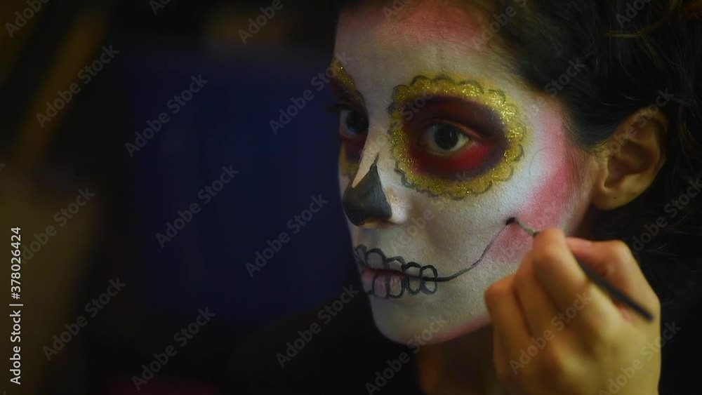 Mujer joven mexicana latina maquillaje catrina calavera día de muertos halloween frente al espejo tradicional festividades colorido esqueleto cara rostro blanco close-up Mujer joven mexicana latina maquillaje catrina calavera día de muertos halloween frente al espejo tradicional festividades colorido esqueleto cara rostro blanco close-up