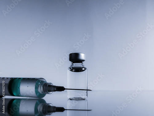 Image with syringe and bottle with light blue background