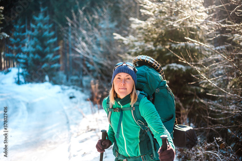 Woman with backpack and snowshoes in the winter mountains.