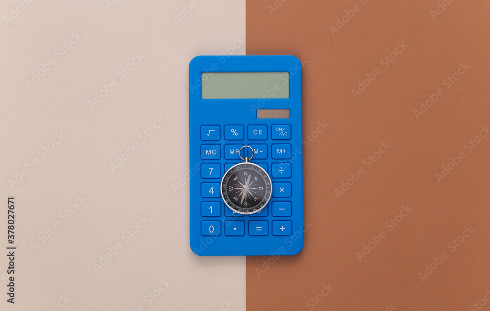 Calculator and compass on beige brown background. Business concept. Top view Calculator and compass on beige brown background. Business concept. Top view