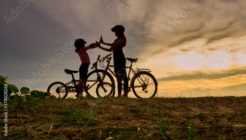 Wallpaper Mural Silhouette Lovely family raise give me five at sunset for relax and freedom. Mom and daughter bicycling at the beach. Lifestyle Concept. Torontodigital.ca