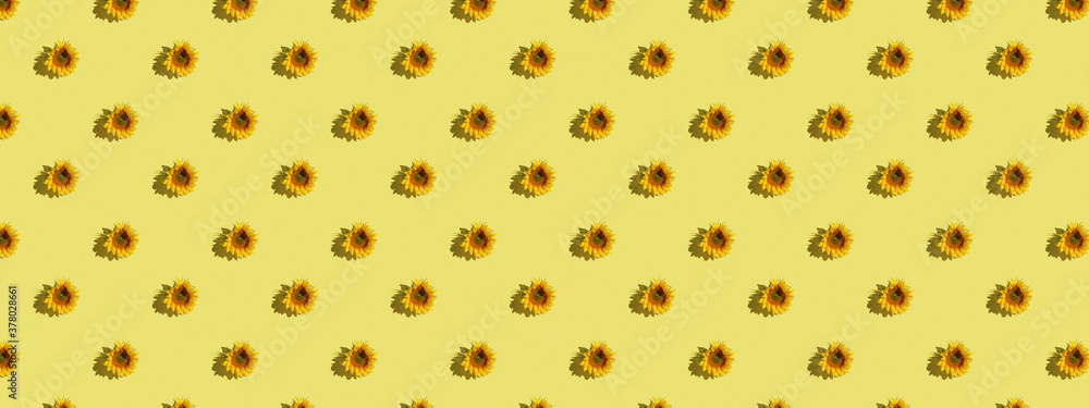Trendy sunlight Summer pattern made with sunflower on bright light yellow background Trendy sunlight Summer pattern made with sunflower on bright light yellow background