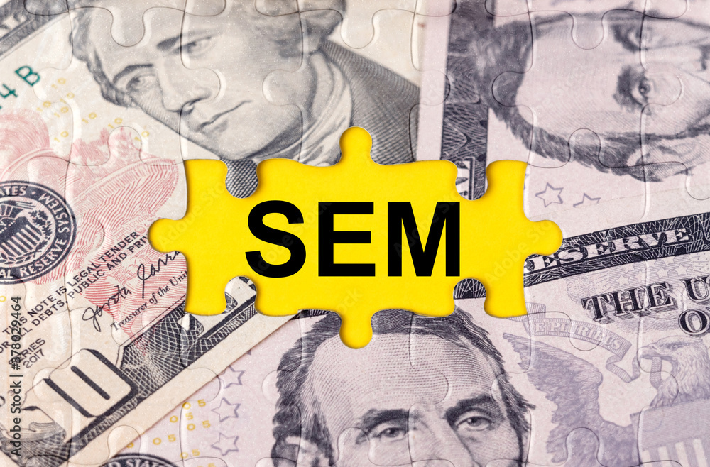 Fototapeta premium Puzzle with the image of dollars in the center of the inscription -SEM