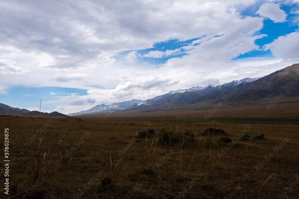 Mountain plateau with cloudy blue sky on background. Rural scenery. Summer nature landscape. Borokhudzir plateau, Kazakhstan. Tourism in Kazakhstan concept.