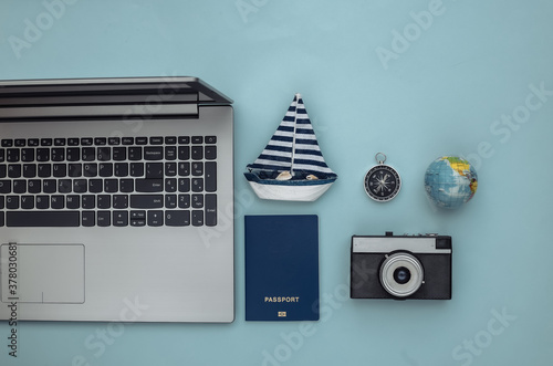 Travel Planning. Laptop and travel accessories on blue background. Top view. Flat lay