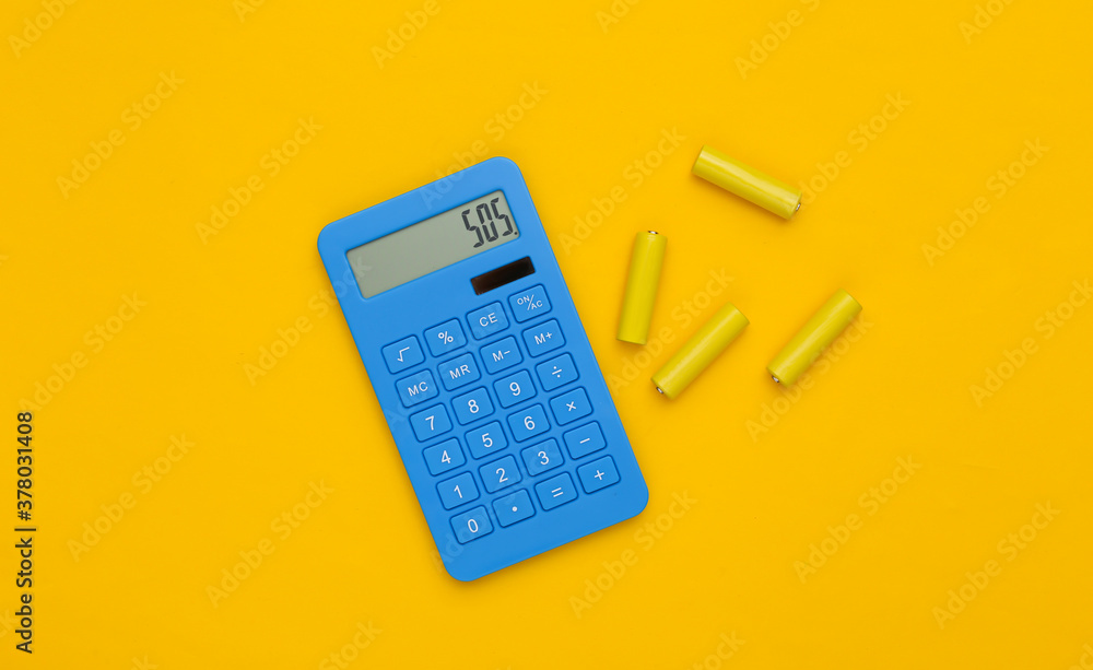 Calculator and batteries on yellow background. Top view Calculator and batteries on yellow background. Top view