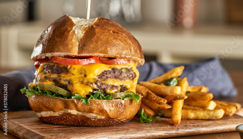 Foto double cheeseburger with american cheese and fries on pretzel  bun