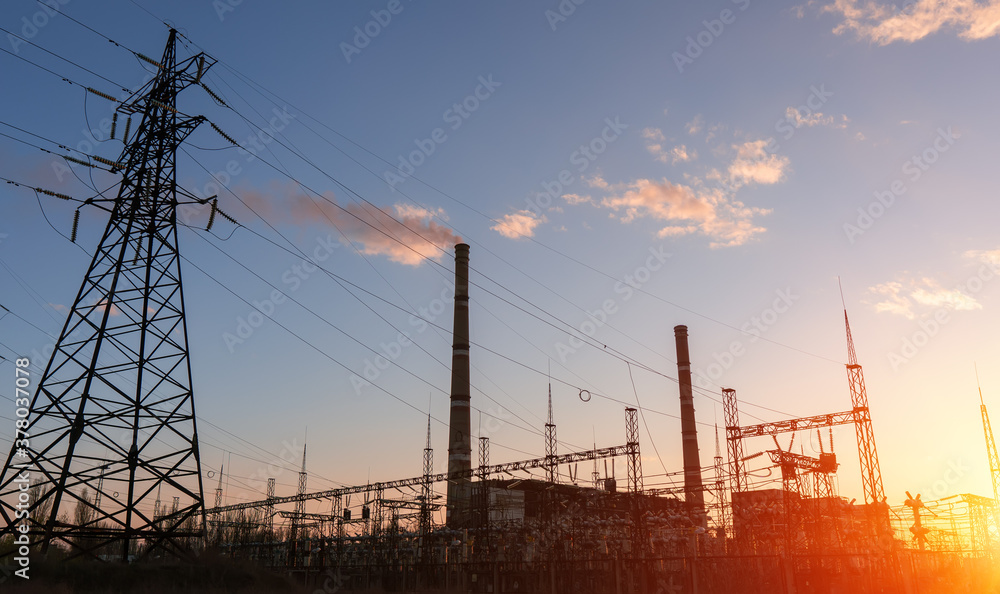 High voltage power lines at sunset. Thermal power plant. High-voltage transformer substation