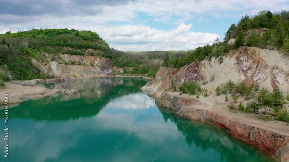 Old quarry lake with beautiful turquoise water. Forest surroundings and red colored cliffs Old quarry lake with beautiful turquoise water. Forest surroundings and red colored cliffs