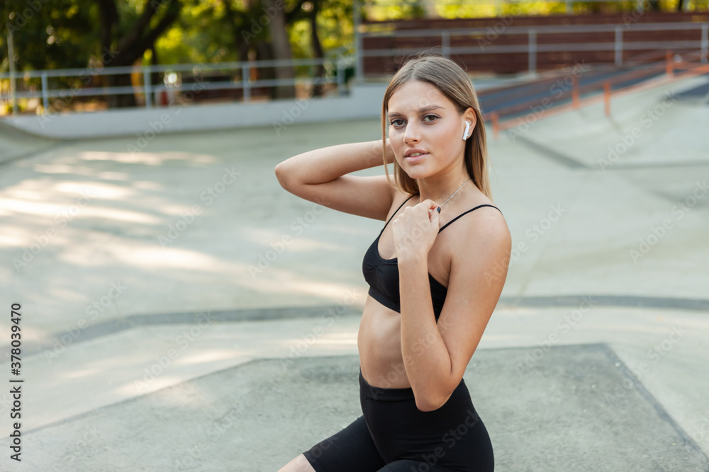 Fit woman posing outdoors after workout Fit woman posing outdoors after workout