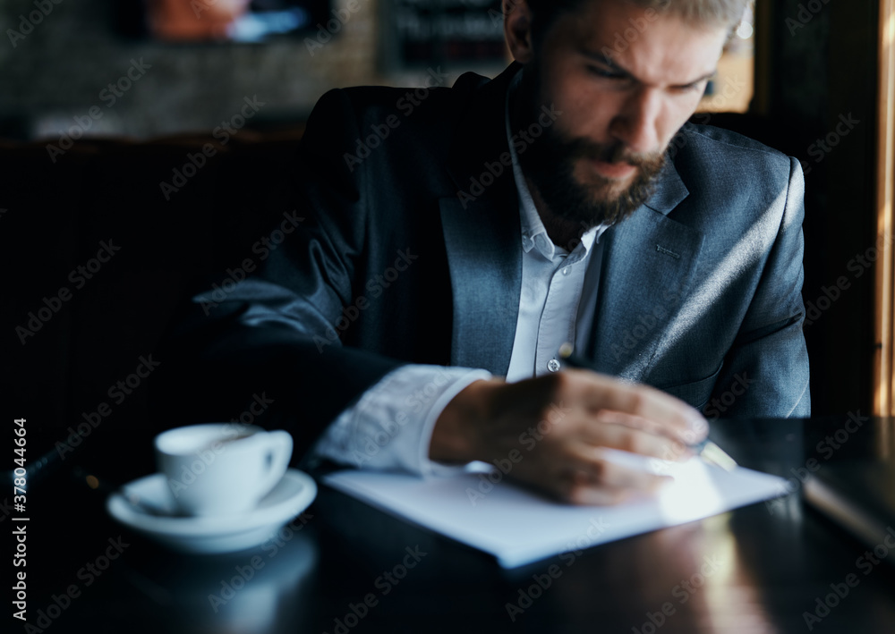 business man sitting at a table in a cafe documents work official coffee cup business man sitting at a table in a cafe documents work official coffee cup