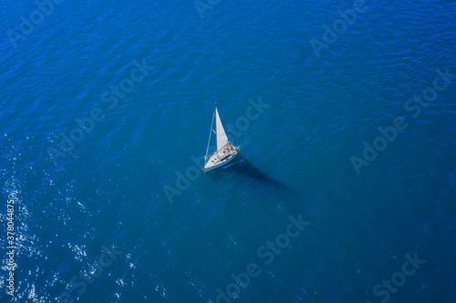 White sailboat movement on turquoise water top view