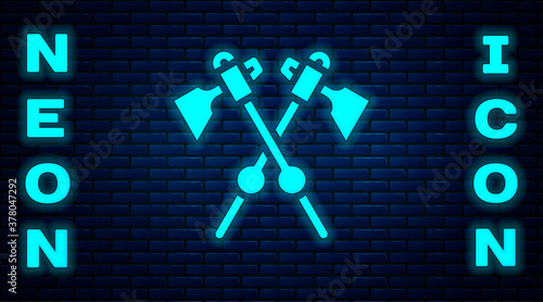 Glowing neon Crossed medieval axes icon isolated on brick wall background. Battle axe, executioner axe. Medieval weapon. Vector.