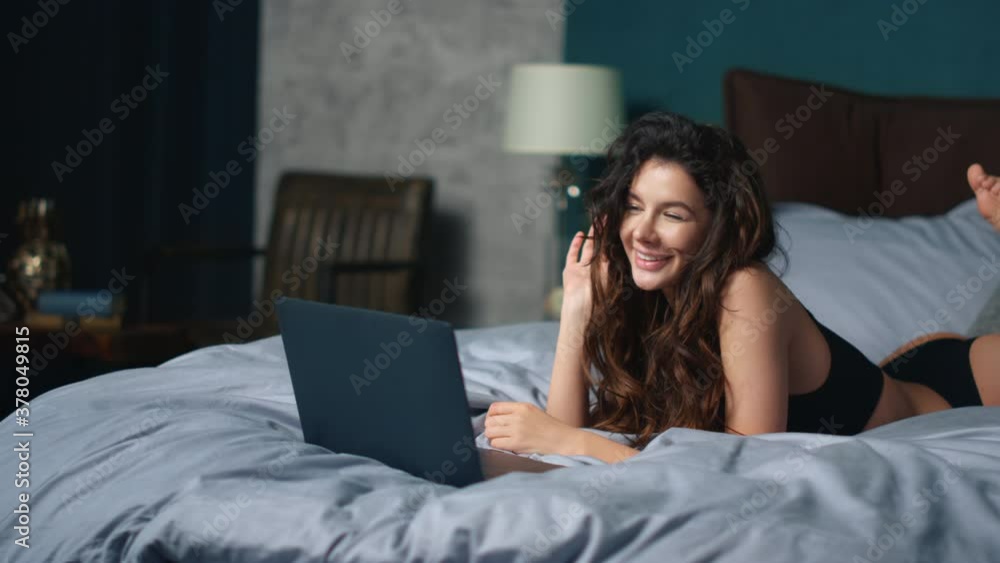 Girl greeting interlocutor laptop screen bed. Sexy woman relaxing with computer. Girl greeting interlocutor laptop screen bed. Sexy woman relaxing with computer.