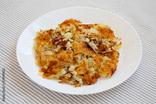 Homemade Fried Hashbrowns on a white plate, side view. Close-up.