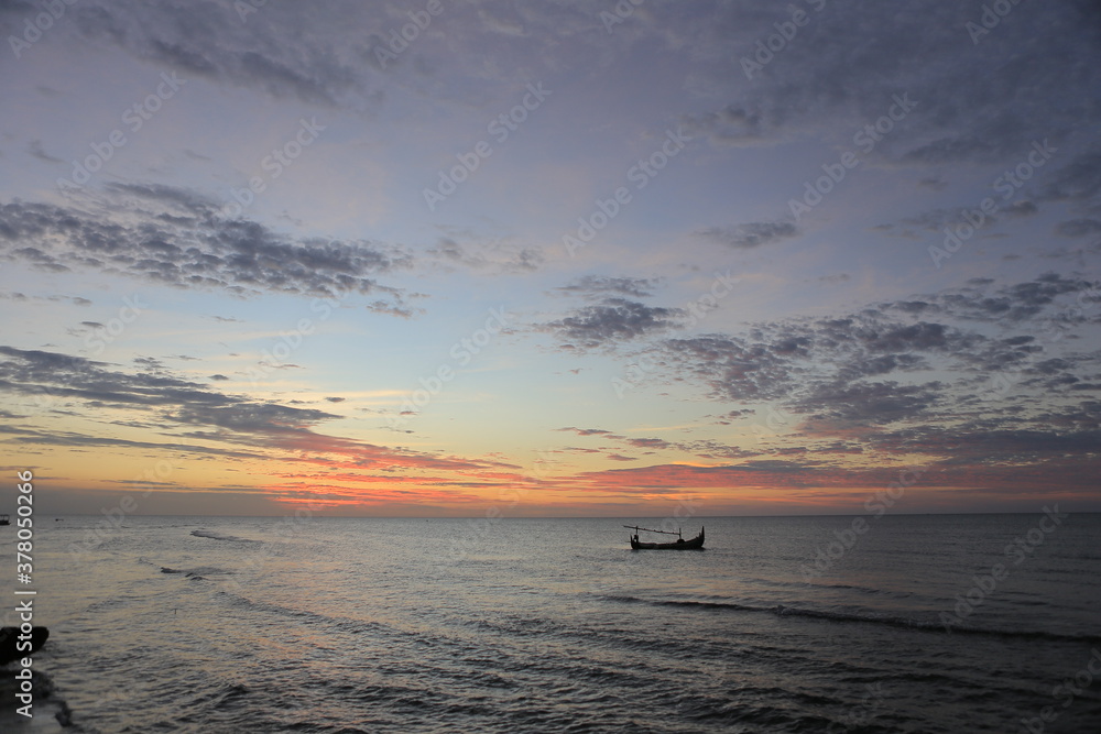 Low orange sunset in dramatic clouds over ocean in Indonesia