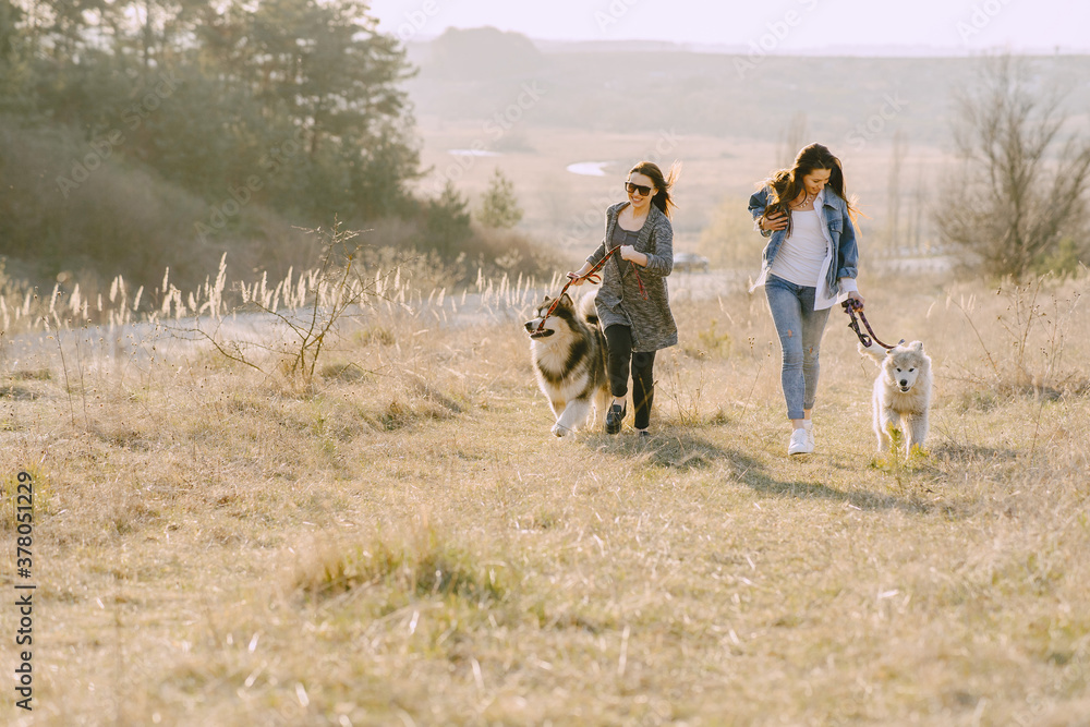 Women in a spring forest. Girls with cute dogs. Stylish friends walks. Women in a spring forest. Girls with cute dogs. Stylish friends walks.