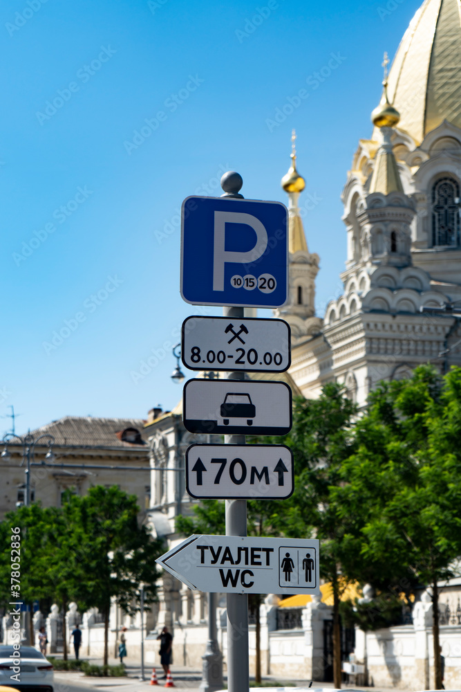 Road post with signs for paid parking, daytime hours, a pointer to the toilet. Road post with signs for paid parking, daytime hours, a pointer to the toilet.