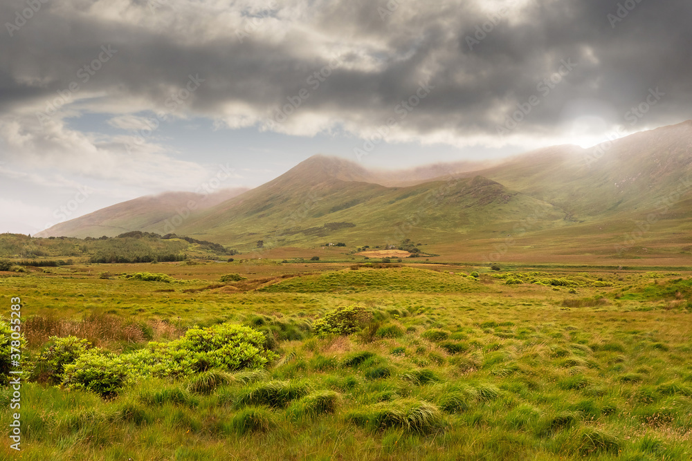 Landscape in Connemara region, Ireland, Beautiful mountains and clouds, Green grass fields.