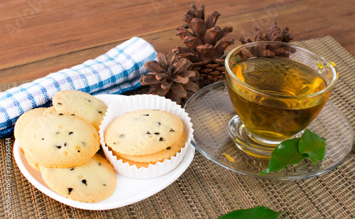 A glass cup of black tea with cookies on a dark greyish marble background. photo