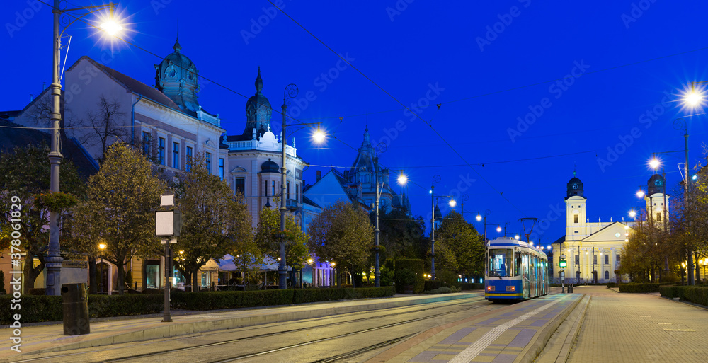Fototapeta premium Nightlife of illuminated central Debrecen streets with Great Protestant Church, Hungary