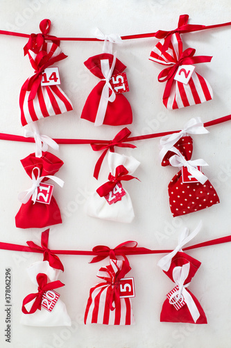 Advent calendar. Red and white bags with sweets on a white background. Gifts for kids