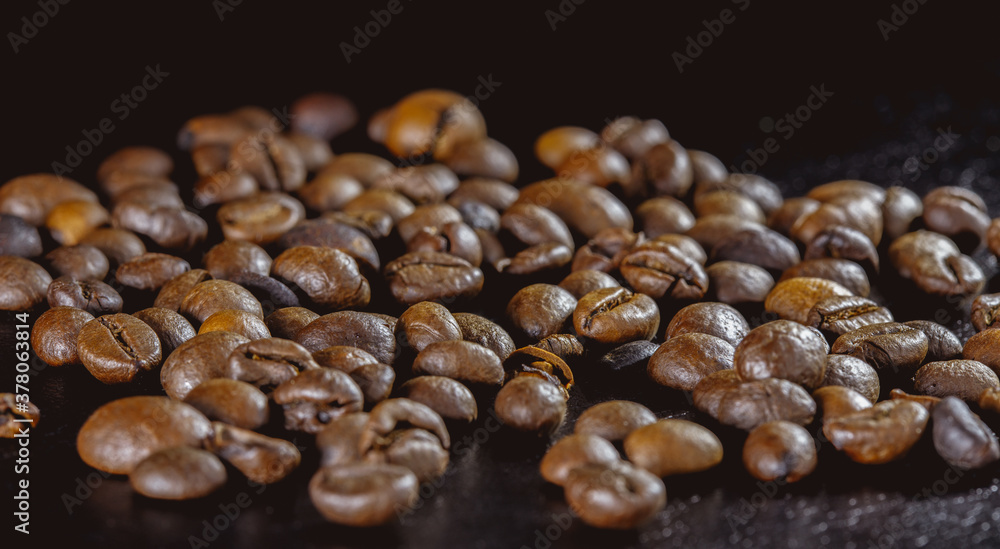 coffee beans on a black surface, a large number, scattered, close-up, low key, dark background, side view coffee beans on a black surface, a large number, scattered, close-up, low key, dark background, side view