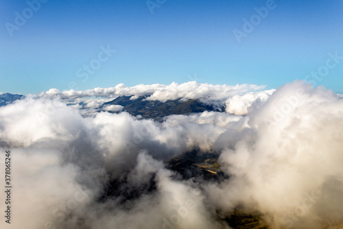 Fototapeta Naklejka Na Ścianę i Meble -  Las montañas aparecen entre las nubes.