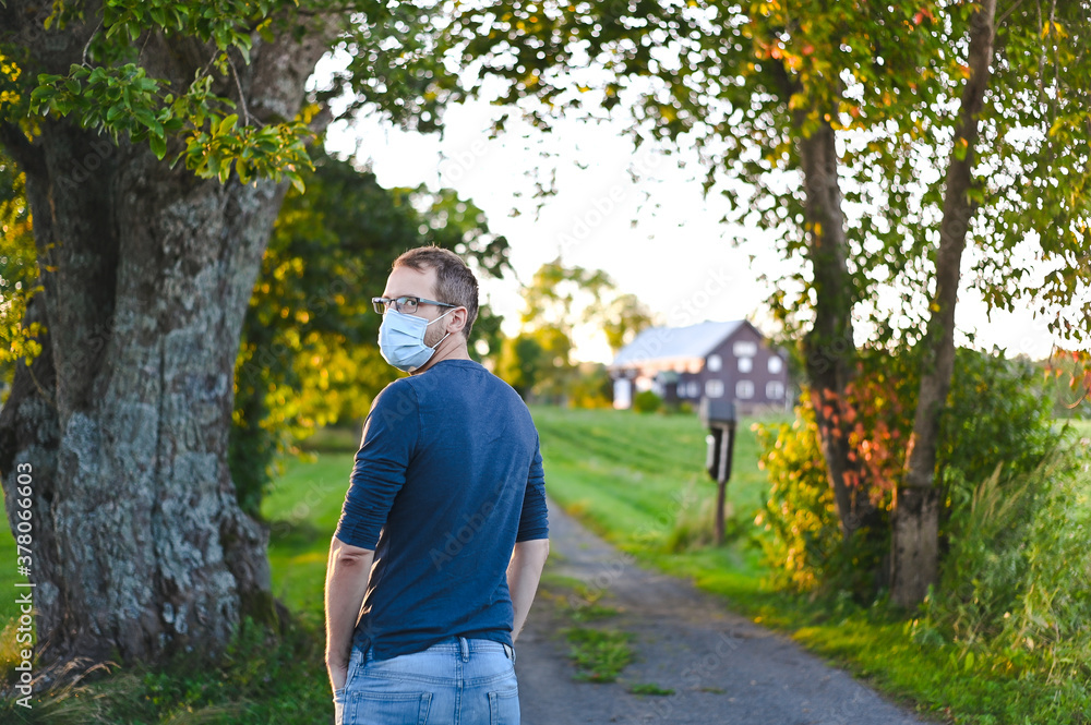 portrait of attractive nerd in long sleeve glasses and protective face mask outside in the park at sunset portrait of attractive nerd in long sleeve glasses and protective face mask outside in the park at sunset