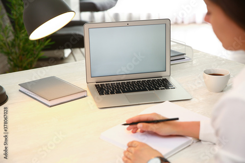 Woman working with modern laptop at white table, closeup. space for design