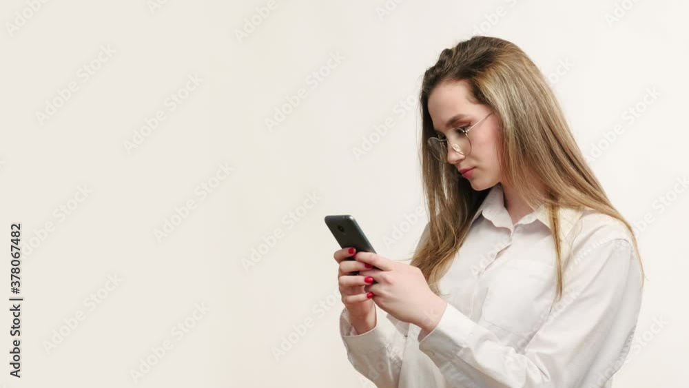 Business chat. Online communication. Confident woman in glasses texting message on phone isolated on white empty space background. Social network. Mobile app. Business chat. Online communication. Confident woman in glasses texting message on phone isolated on white empty space background. Social network. Mobile app.
