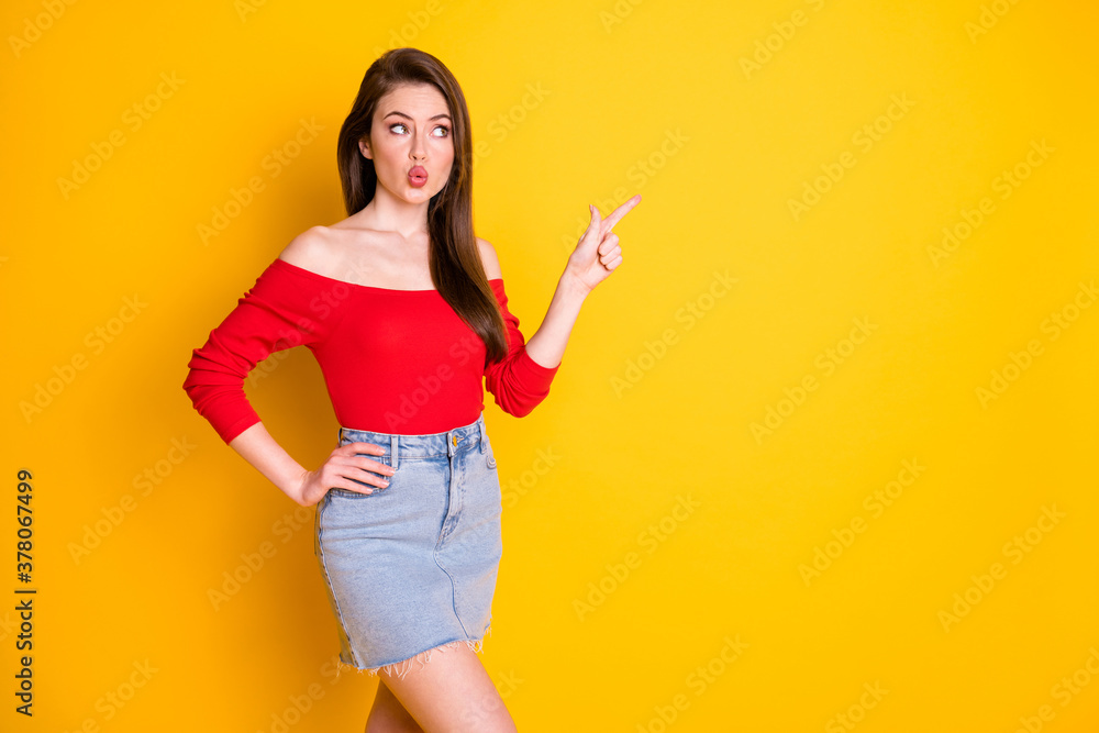 Photo of pretty lovely young girl directing finger look empty space best proposition wear shirt uncovered shoulders denim mini skirt isolated vibrant yellow color background Photo of pretty lovely young girl directing finger look empty space best proposition wear shirt uncovered shoulders denim mini skirt isolated vibrant yellow color background