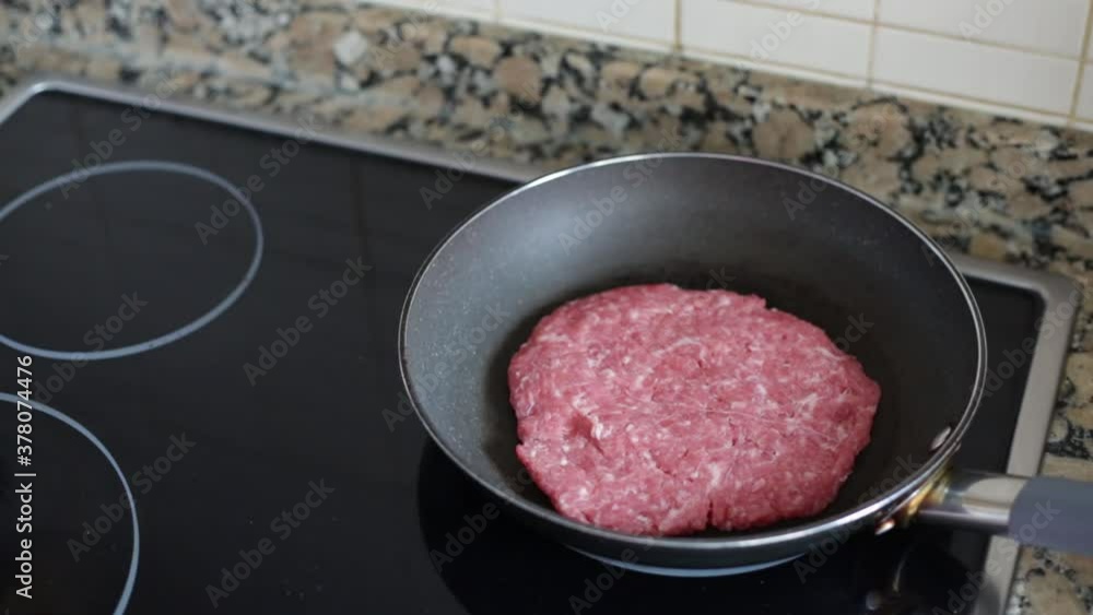 putting a hamburger in a frying pan putting a hamburger in a frying pan