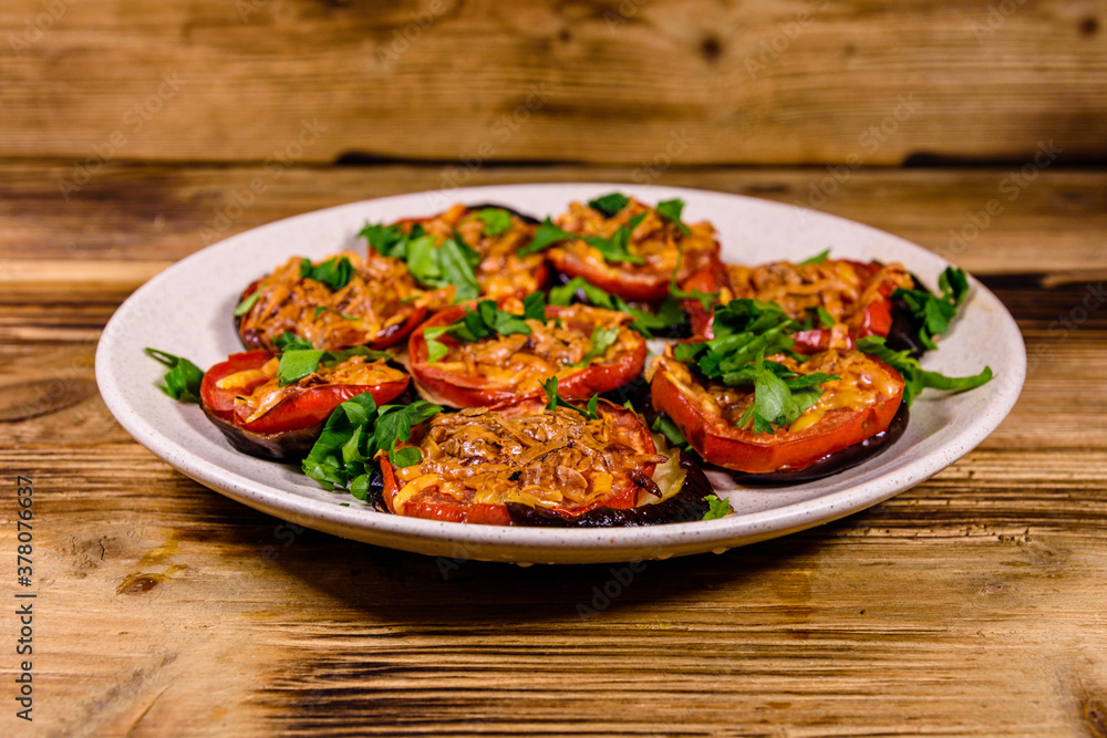 Baked eggplants with tomatoes and cheese in a ceramic plate Baked eggplants with tomatoes and cheese in a ceramic plate