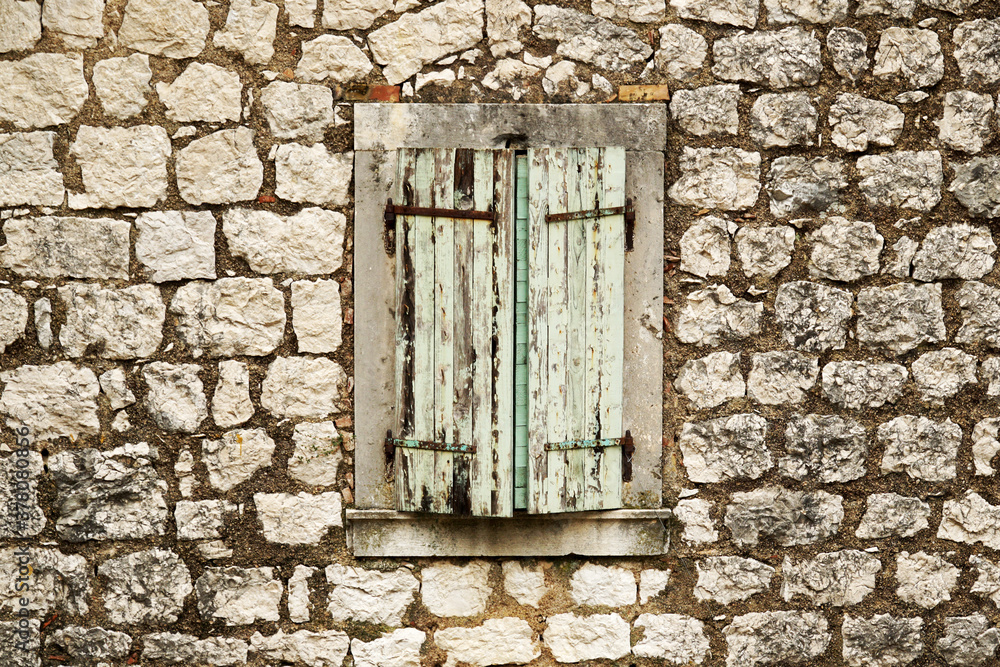 Wooden shutters on a window opening in an old stone house. Wooden shutters on a window opening in an old stone house.