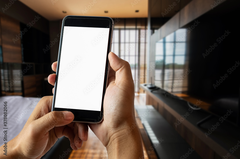 A man hand holding smart phone device in the bright office room interior.. A man hand holding smart phone device in the bright office room interior..