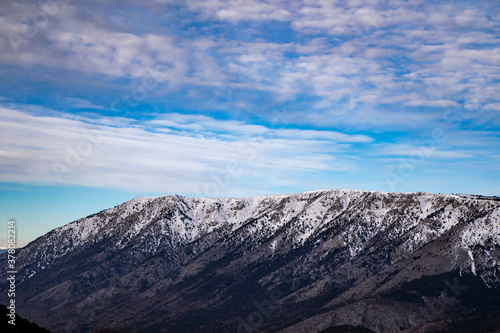 Fototapeta Naklejka Na Ścianę i Meble -  Blue sky and white clouds behind the snowy mountains.