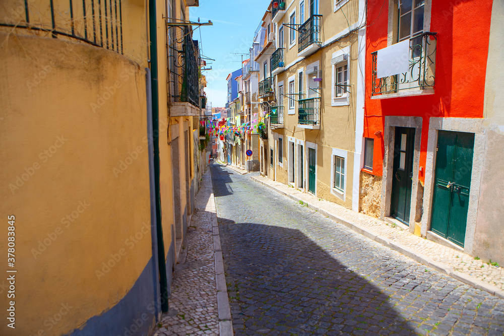 Narrow street of Lisbon with colorful flags 