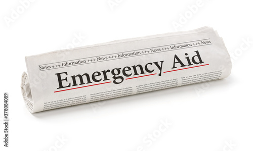 Rolled newspaper with the headline Emergency Aid